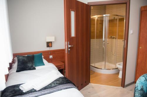 a bedroom with a bed and a shower and a toilet at Geris in Częstochowa