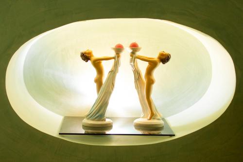 two figurines on a shelf in front of a mirror at Casa Bormioli - Maison de Charme in Procida