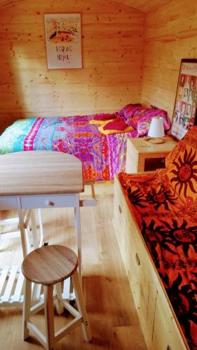 - une chambre avec un lit, une table et un tabouret dans l'établissement Nîmes en Garrigues, à Nîmes