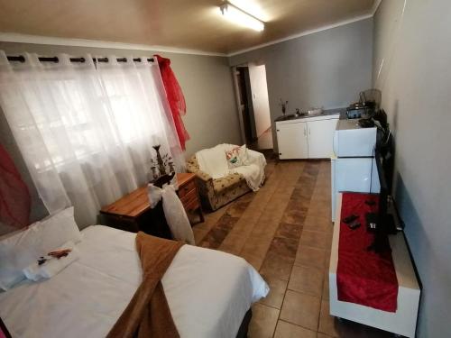 um pequeno quarto com 2 camas e uma cozinha em Angel's Corner em Cidade do Cabo
