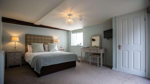 a bedroom with a bed and a desk and a window at The Wyndham Hotel in Clearwell