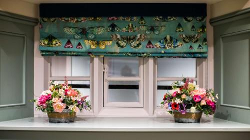 a window with two flowers and butterflies on it at The Wyndham Hotel in Clearwell