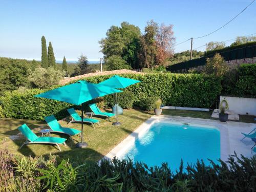 une piscine avec chaises et parasols dans une cour dans l'établissement Côte d'Azur, Villa New Gold Dream with heated and privat pool, sea view, à Le Rouret
