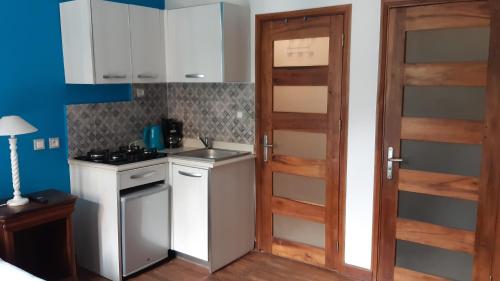 a kitchen with a door and a sink and a stove at Résidence Le Hublot in Antananarivo