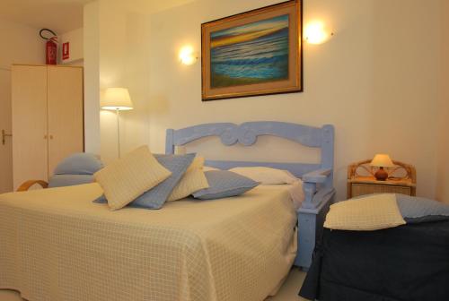1 dormitorio con 1 cama azul y 2 almohadas en Appartamento- Murex, en Marina di Castagneto Carducci
