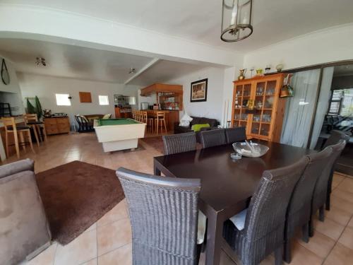 a living room with a dining room table and chairs at Au Plais De Langebaan at Palm Tree Villa in Langebaan