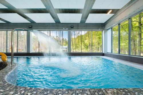 米茲多洛傑的住宿－Aquamarina Onyx Marina Invest，一座建筑物内带喷泉的游泳池