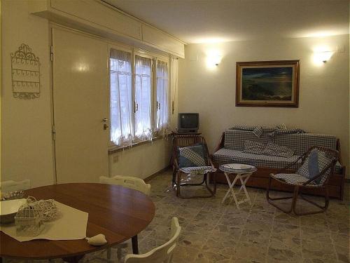 sala de estar con mesa y sofá en Bougainvillea 3+3, en Marina di Castagneto Carducci