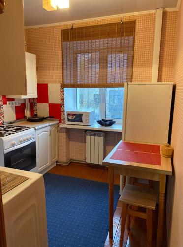 Михайлівська квартира في جيتومير: مطبخ صغير مع طاولة وميكروويف
