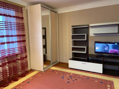 een woonkamer met een televisie en een groot raam bij Михайлівська квартира in Zhytomyr