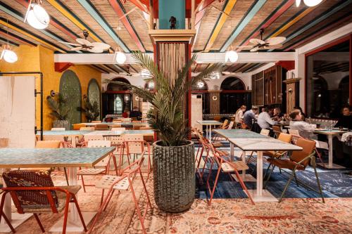 a restaurant with tables and chairs and a potted plant at Domaine de Ronchinne - Château et Ecuries in Maillen