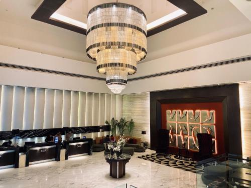 um lobby de um hotel com um lustre em The Landmark Towers em Kanpur