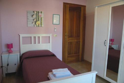 a small bedroom with a bed and a mirror at Le Anfore in Marino