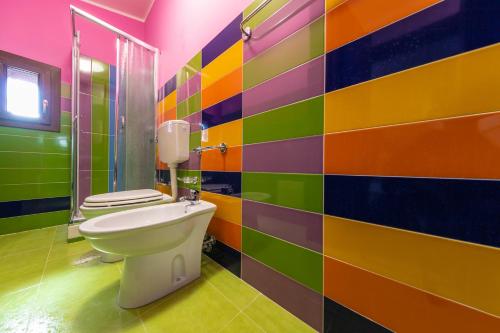 ein Bad mit einem WC in einer farbenfrohen Wand in der Unterkunft Luxury Villas in Lascari