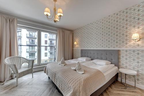 sypialnia z łóżkiem i dużym oknem w obiekcie Apartamenty Apartinfo Chmielna Park w Gdańsku