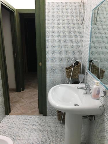 a bathroom with a sink and a mirror at Cottage Su Giudeu in Chia