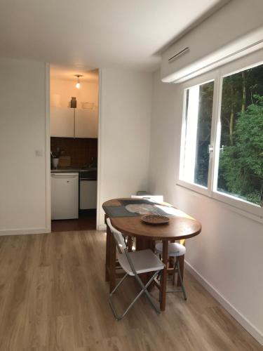 une cuisine et une salle à manger avec une table et des chaises dans l'établissement Entre forêt et Mer au Calme, à Trouville-sur-Mer