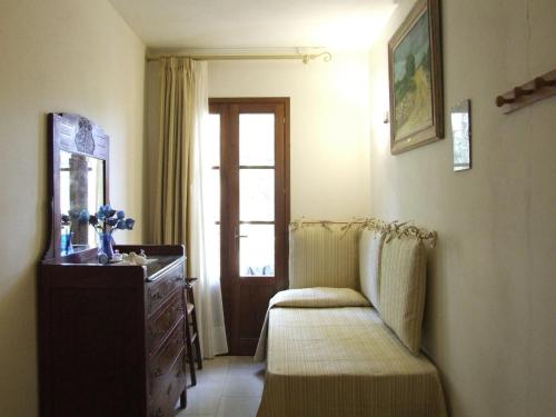 Zimmer mit einem Stuhl, einer Kommode und einem Fenster in der Unterkunft Villa La Quercia-Fresia in Sassetta