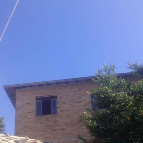 un bâtiment en briques avec deux fenêtres au-dessus dans l'établissement Apartamento em Ibitipoca, à Conceição da Ibitipoca