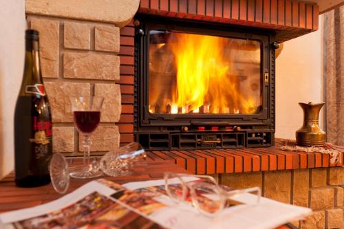 a fireplace with a glass of red wine and a table with wine glasses at Touring Cheminée in Grächen