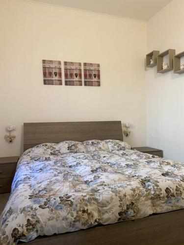a bed in a bedroom with two pictures on the wall at B&B La Piccola Corte in Polpenazze del Garda