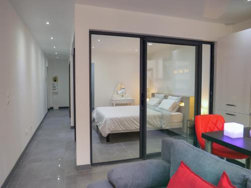 een slaapkamer met een bed, een bank en een spiegel bij Le Drouhouse + parking privé in Nancy