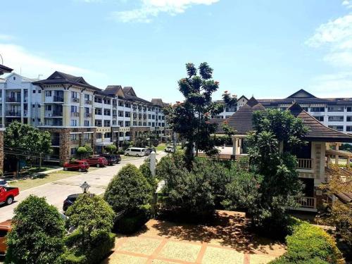 an apartment complex with cars parked in a parking lot at ONE OASIS DAVAO a4 FREE POOL 3 MIN WALK SM MALL in Davao City