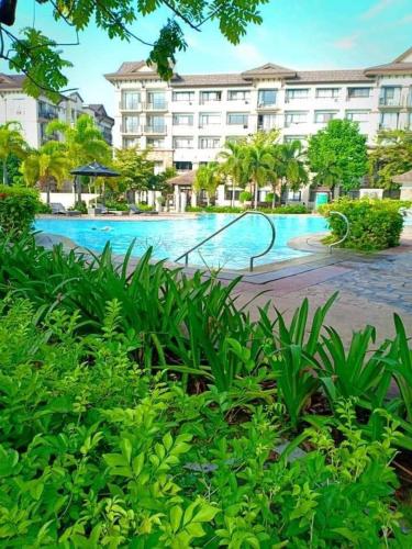 a swimming pool with a slide in front of a building at ONE OASIS DAVAO a4 FREE POOL 3 MIN WALK SM MALL in Davao City