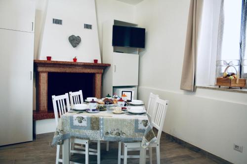 una sala da pranzo con tavolo, sedie e camino di B&B La Piccola Corte a Polpenazze del Garda