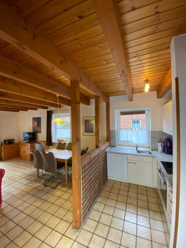 uma cozinha e sala de jantar com uma mesa num quarto em Tegeler Plate 26 em Wangerland
