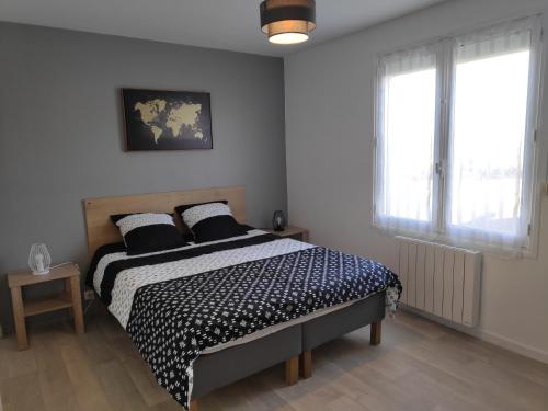 a bedroom with a bed with black and white sheets at Le petit Husseau in Montlouis-sur-Loire