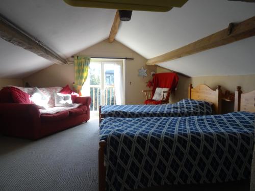 1 dormitorio con 2 camas y sofá en Charming French Gite in the heart of quiet Gorron, en Gorron