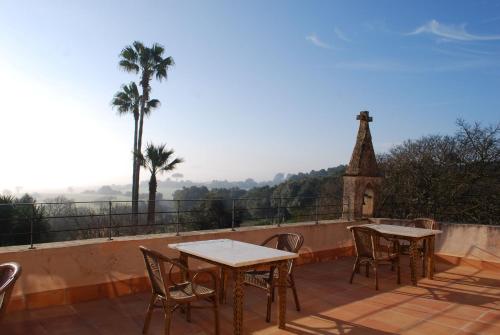 a patio with tables and chairs and a church at Agroturismo Son Sant Andreu in Petra