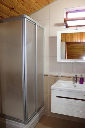 ein Bad mit einer Dusche und einem Waschbecken in der Unterkunft Plaj Hotel in Cıralı