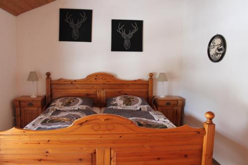 una camera con letto in legno e due quadri appesi al muro di Ferienwohnungen Woidzauber a Zwiesel