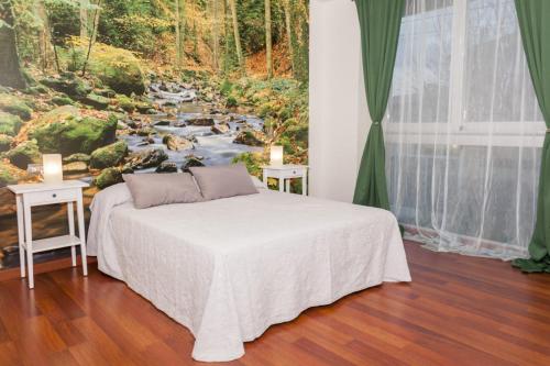 a bedroom with a bed with a painting of a river at Chalet de lujo in Murcia