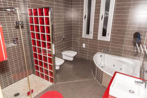 a bathroom with a tub and a toilet and a sink at Chalet de lujo in Murcia