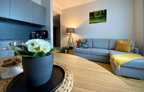 uma sala de estar com um vaso com flores sobre uma mesa em Riga A new designed cosy family apartment em Riga