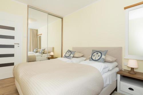 コウォブジェクにあるJantar Apartamenty Exclusive Polanki Park SPAの白いベッドルーム(大型ベッド1台、鏡付)