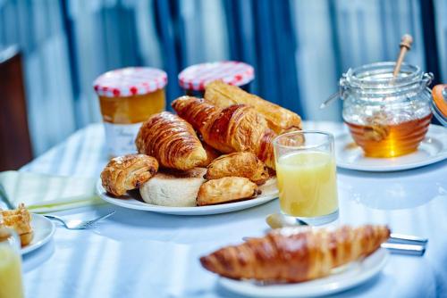 a table with two plates of pastries and orange juice at NYX Hotel London Holborn by Leonardo Hotels in London