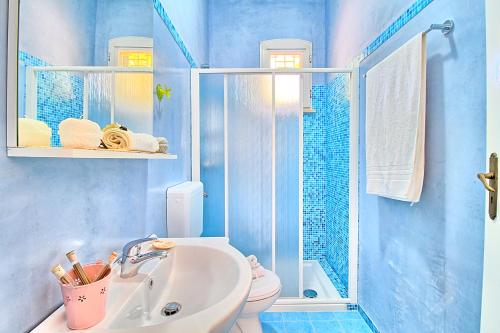 La salle de bains bleue est pourvue d'un lavabo et de toilettes. dans l'établissement Ville Belvedere Luxury Accommodation, à Gagliano del Capo