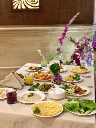 a table with many plates of food on it at Violet Al Azizia Hotel MASJID Al Qatari in Makkah
