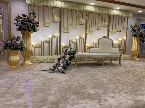 a room with a couch and flowers and candles at Violet Al Azizia Hotel MASJID Al Qatari in Makkah