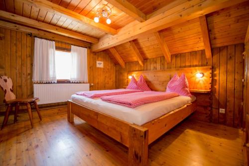a bedroom with a bed in a wooden room at Holzblockhäuser Fam. Schabus in Hermagor