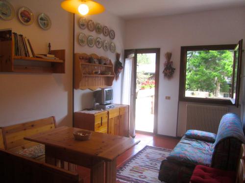 a living room with a table and a couch at Miniappartamento Dolomiti in Selva di Cadore