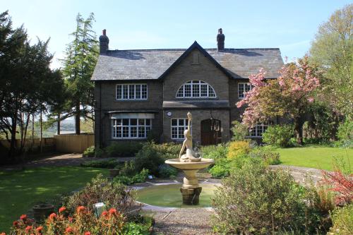 a house with a fountain in the front yard at Gellihaf House in Blackwood
