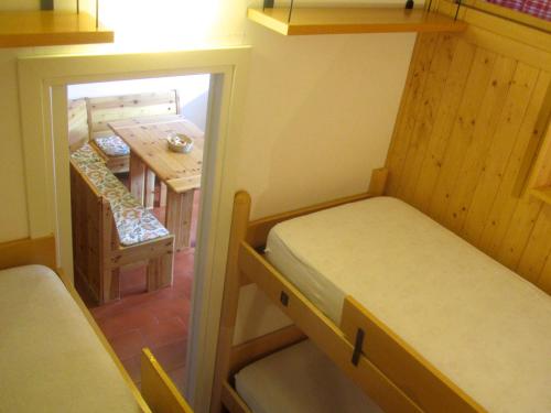 a small room with a small bed and a table at Miniappartamento Dolomiti in Selva di Cadore