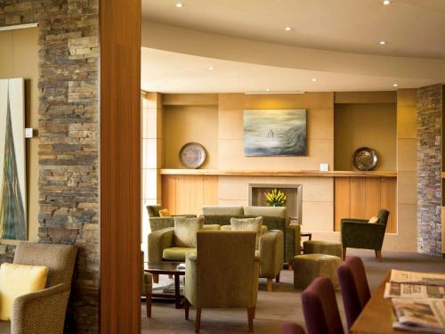 a waiting room with chairs and a fireplace at The Sebel Launceston in Launceston