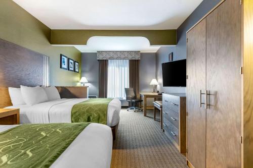 a hotel room with two beds and a television at Comfort Suites Southgate-Detroit in Southgate