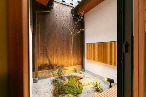 a door leading into a courtyard with a plant at Mokuren Traditional Boutique Townhouse in Kyoto